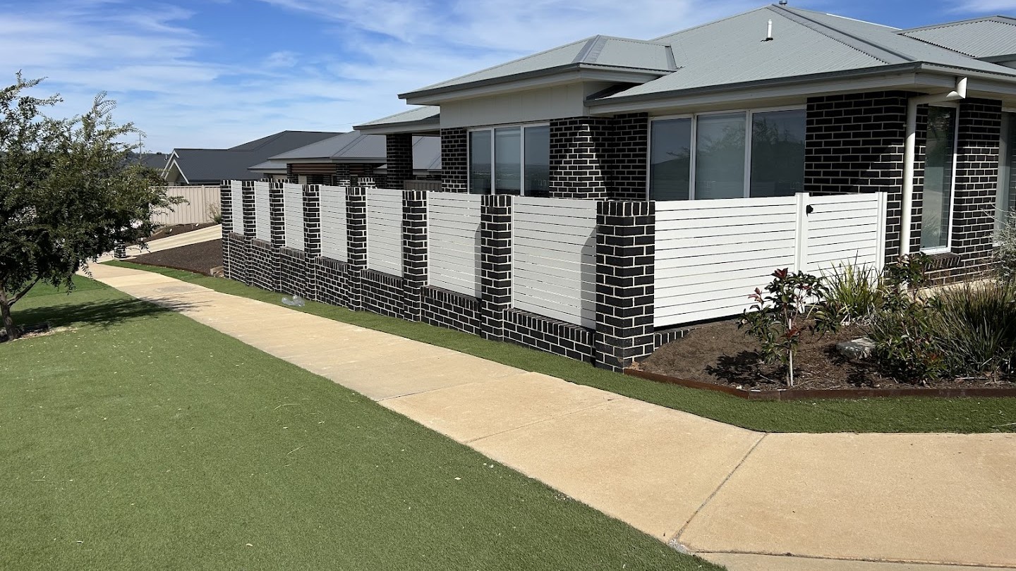 A crisp white modular privacy wall and fresh turf at a new Wagga Wagga home, built by Anesbury Fencing & Construction