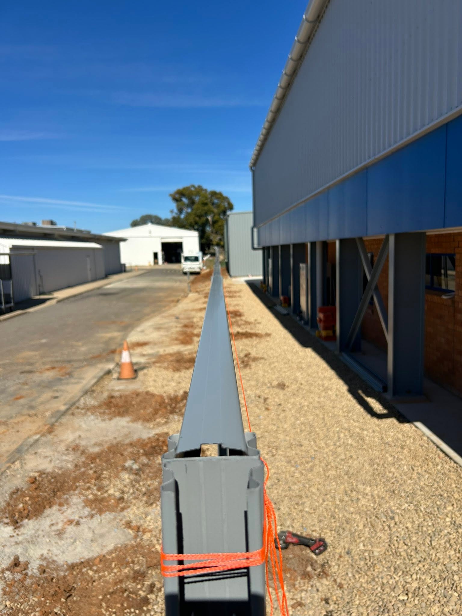 A long Colorbond fence run beside a commercial building – a real job by Anesbury Fencing & Construction in Wagga Wagga