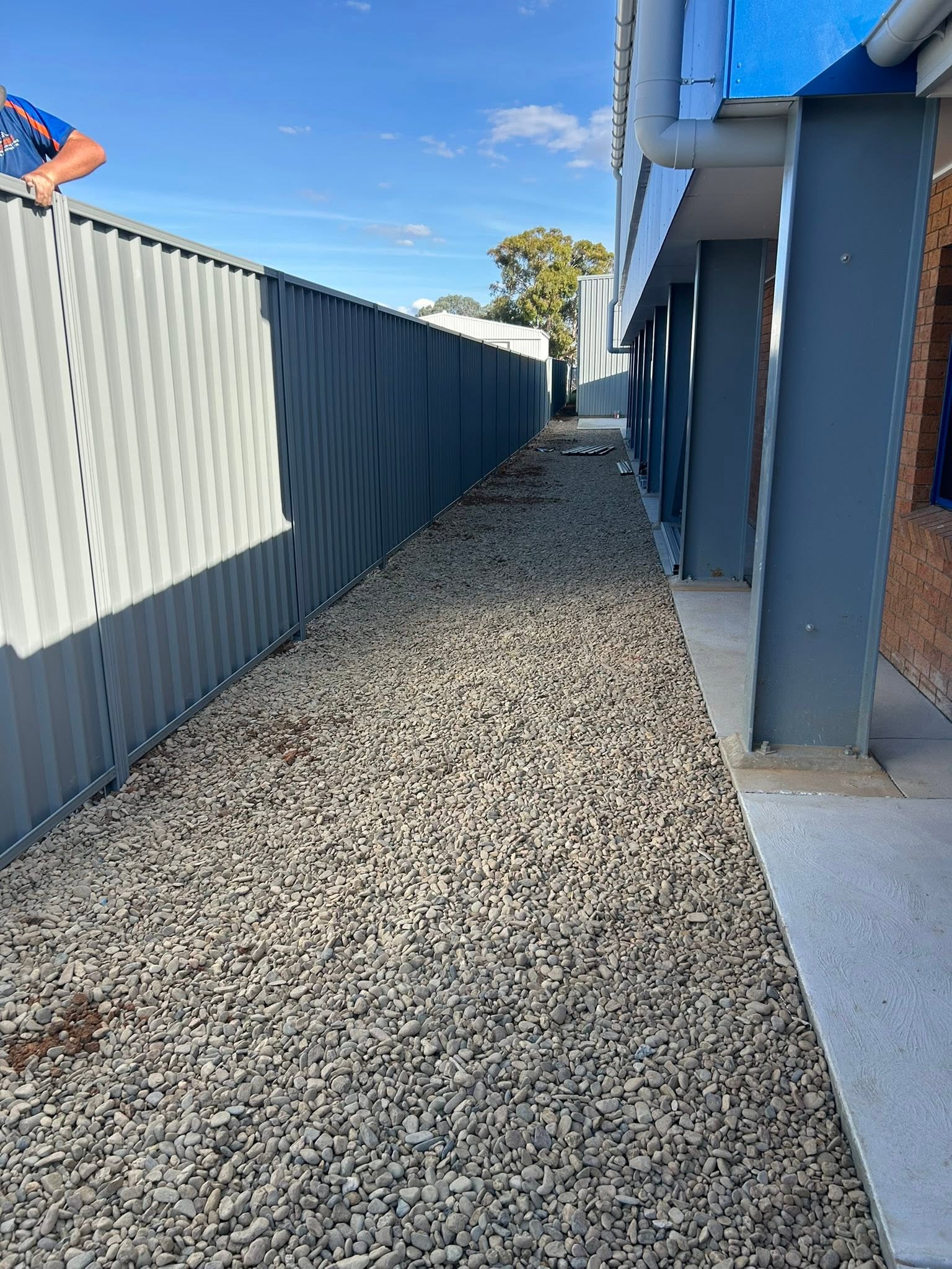 A steel-grey Colorbond fence along a fresh gravel path – a real job by Anesbury Fencing & Construction in Wagga Wagga