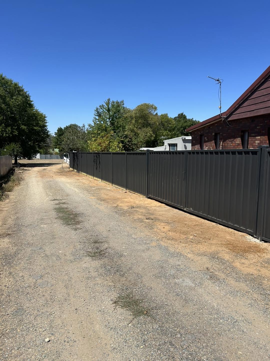 A dark Colorbond boundary fence along a laneway – a real job by Anesbury Fencing & Construction in Wagga Wagga