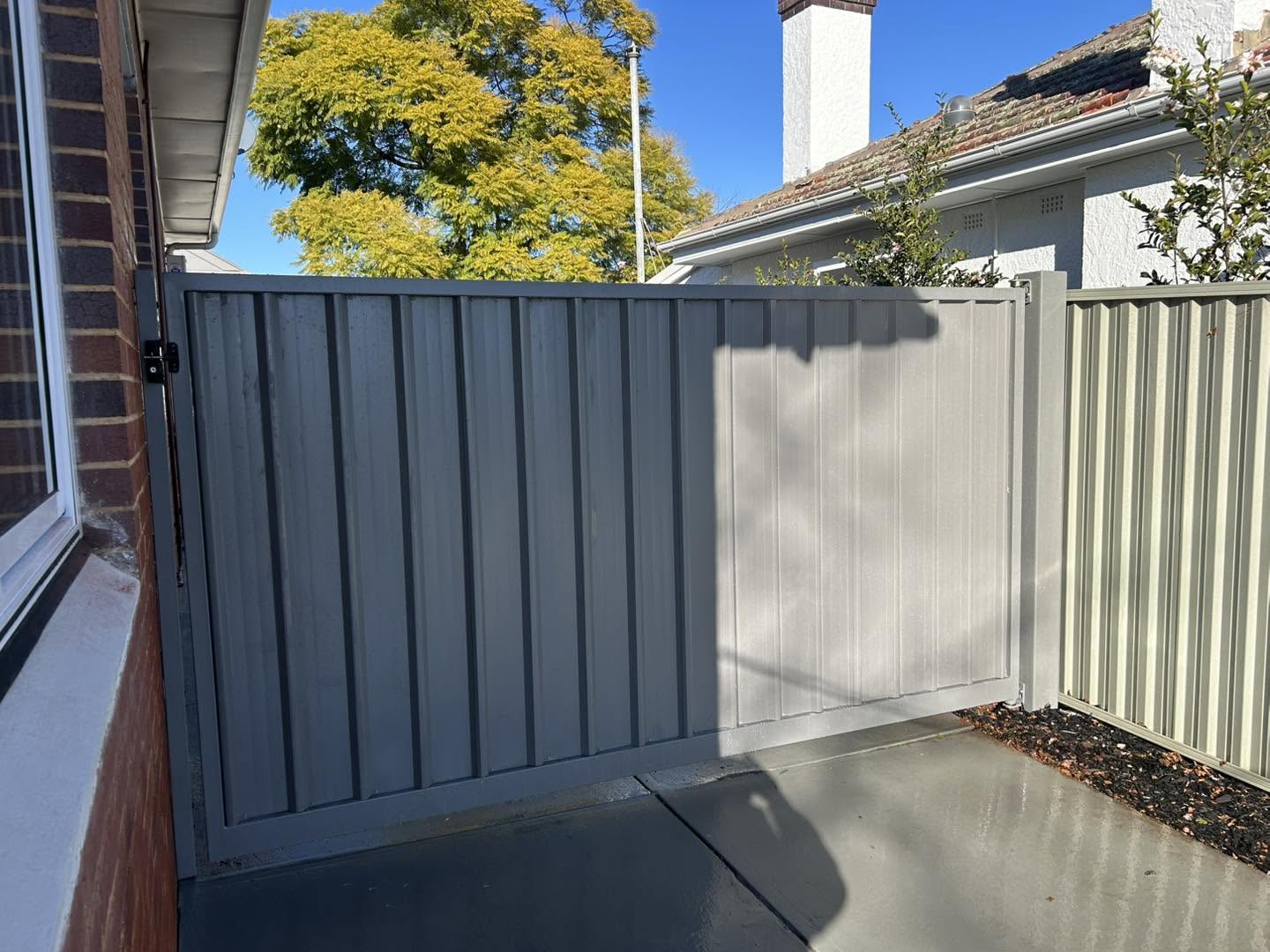 A cream Colorbond fence and gate against brick – a real job by Anesbury Fencing & Construction in Wagga Wagga