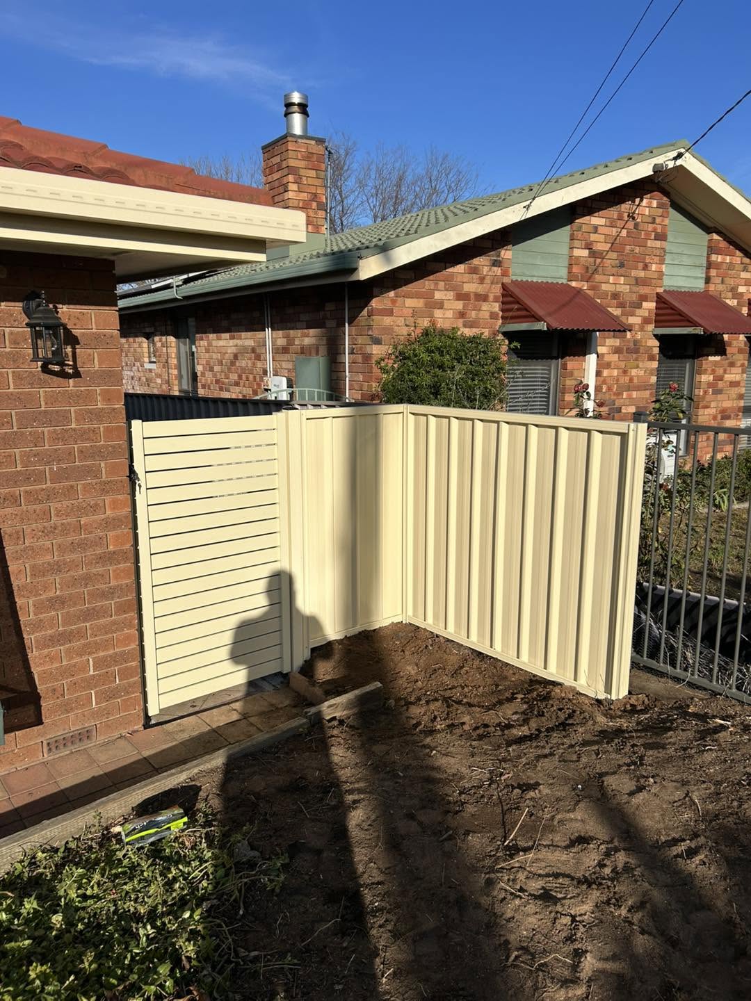 Cream Colorbond fence panels at a brick home – a real job by Anesbury Fencing & Construction in Wagga Wagga