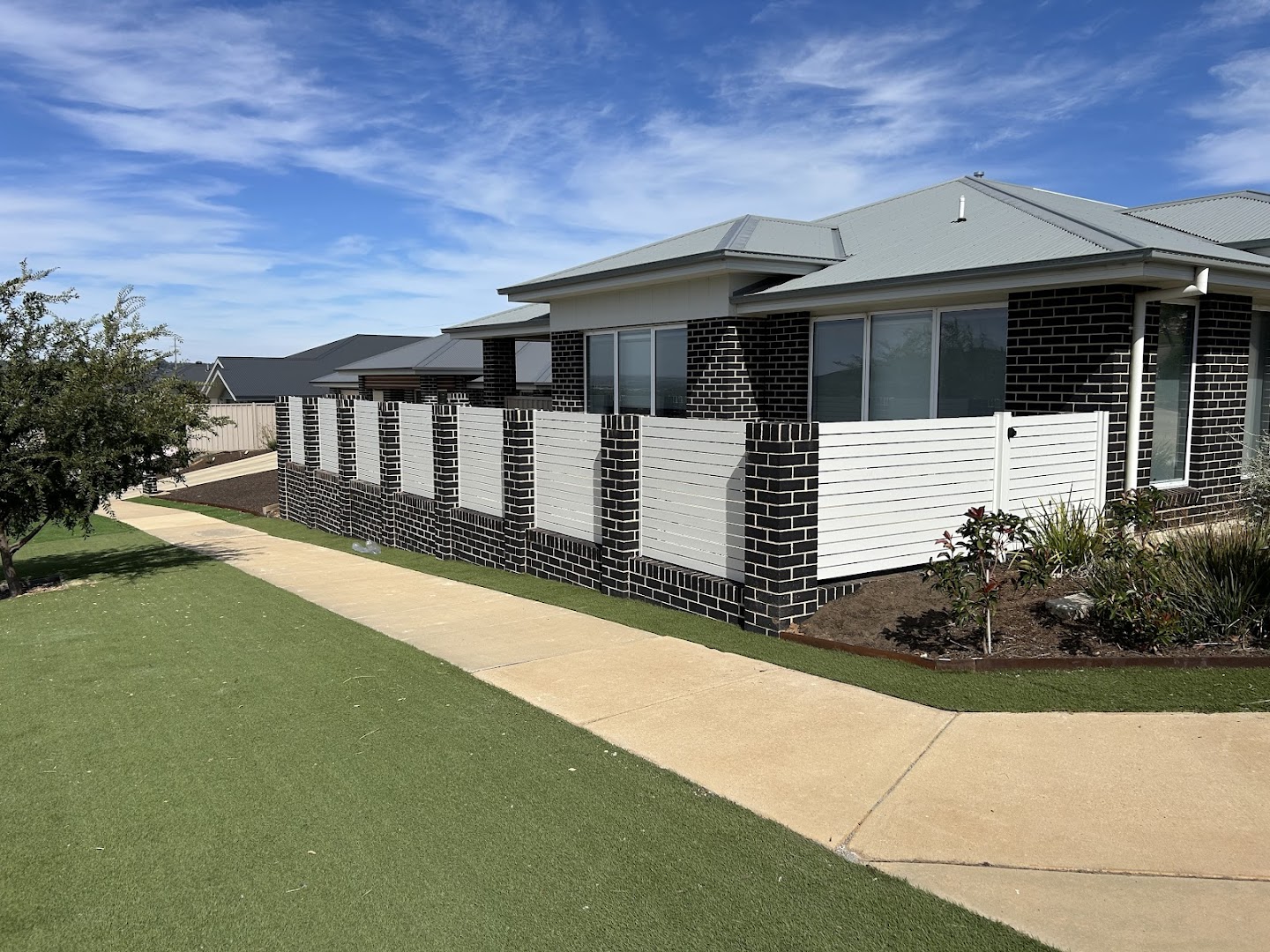 A white modular privacy wall and fresh turf at a new home – a real job by Anesbury Fencing & Construction in Wagga Wagga