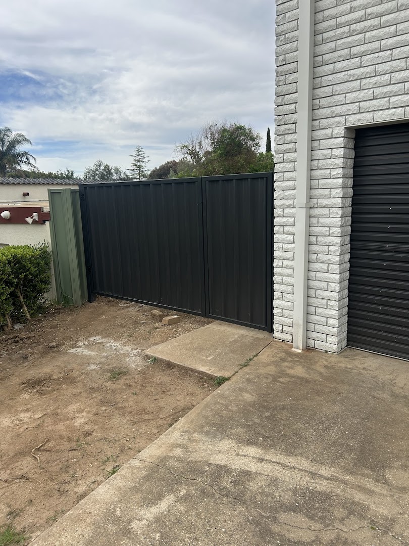 A black Colorbond gate and fence beside a garage – a real job by Anesbury Fencing & Construction in Wagga Wagga