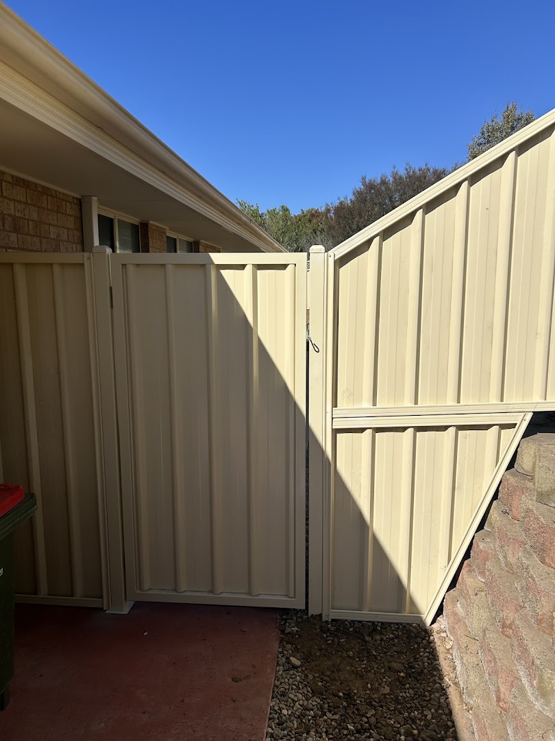 A cream Colorbond fence and gate corner at a brick house – a real job by Anesbury Fencing & Construction in Wagga Wagga