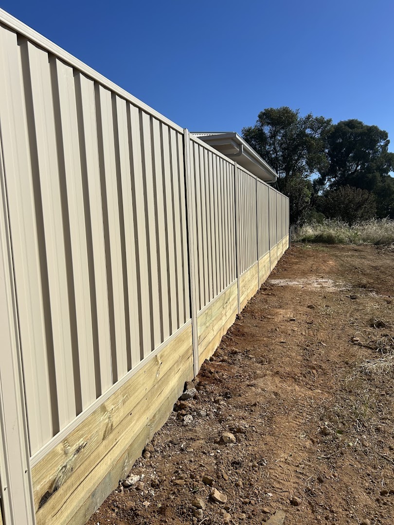 A Colorbond fence built over a timber sleeper retaining wall – a real job by Anesbury Fencing & Construction in Wagga Wagga